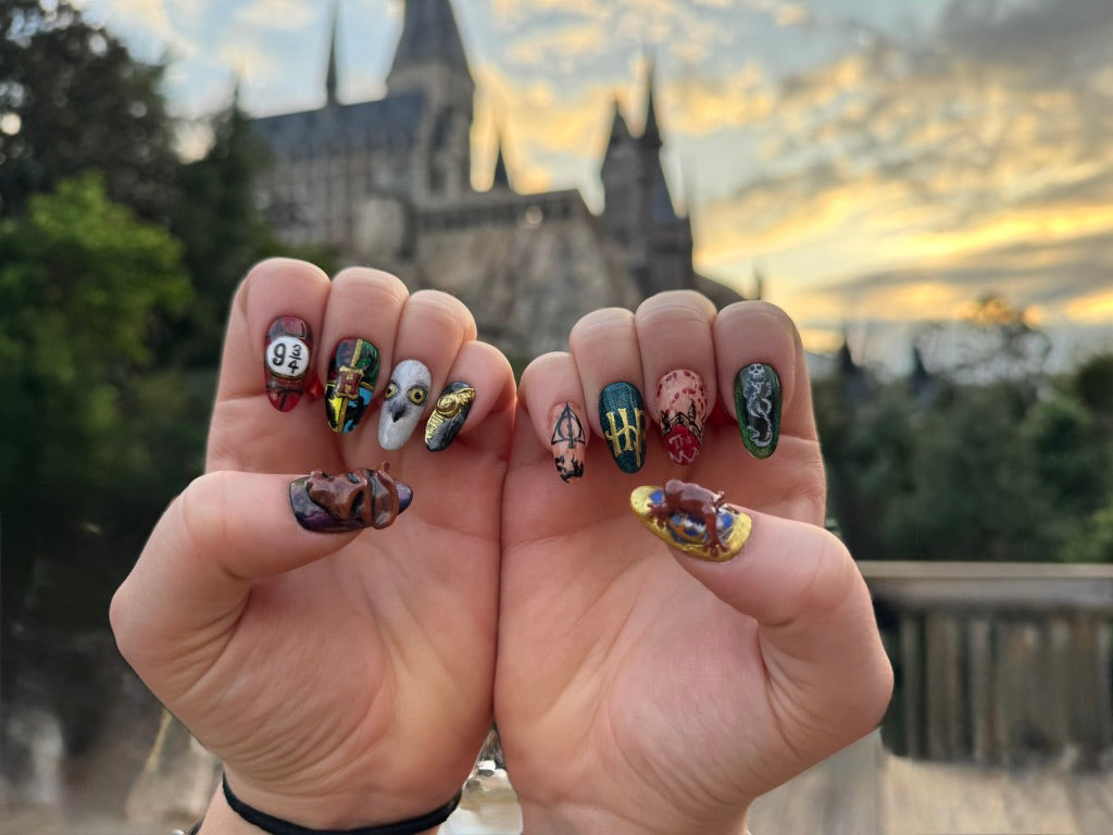 Two hands wearing hand-painted glow-in-the-dark Halloween press-on nails under blacklight